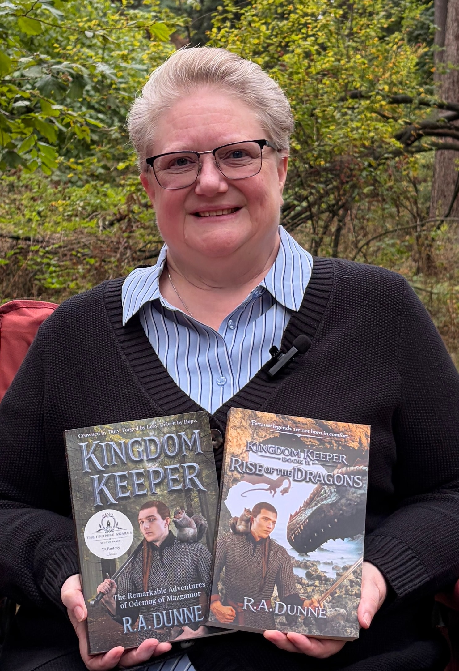 R.A. Dunne holding both Kingdom Keeper books outdoors